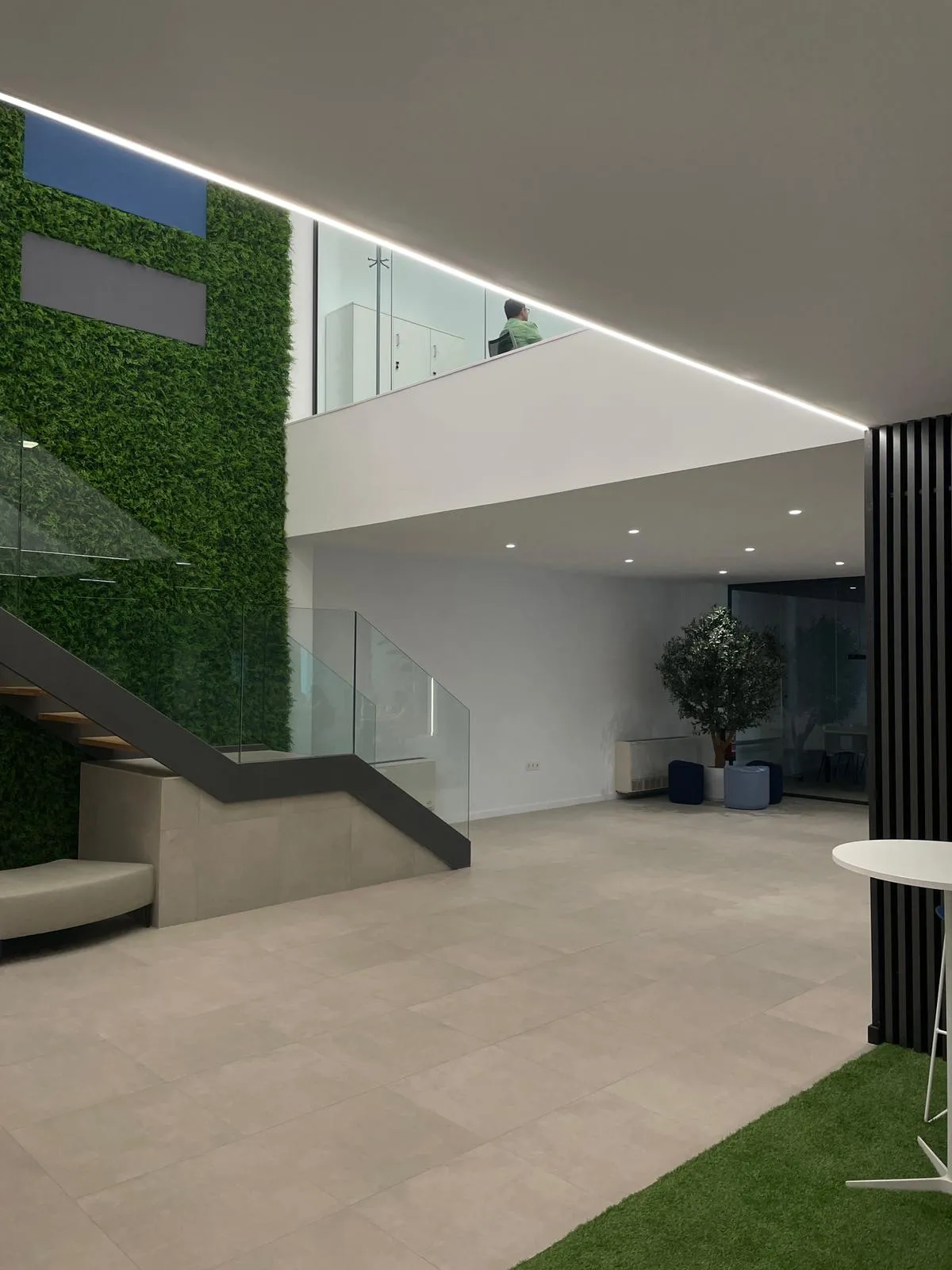 Recepción de oficinas a doble altura con iluminación LED integrada