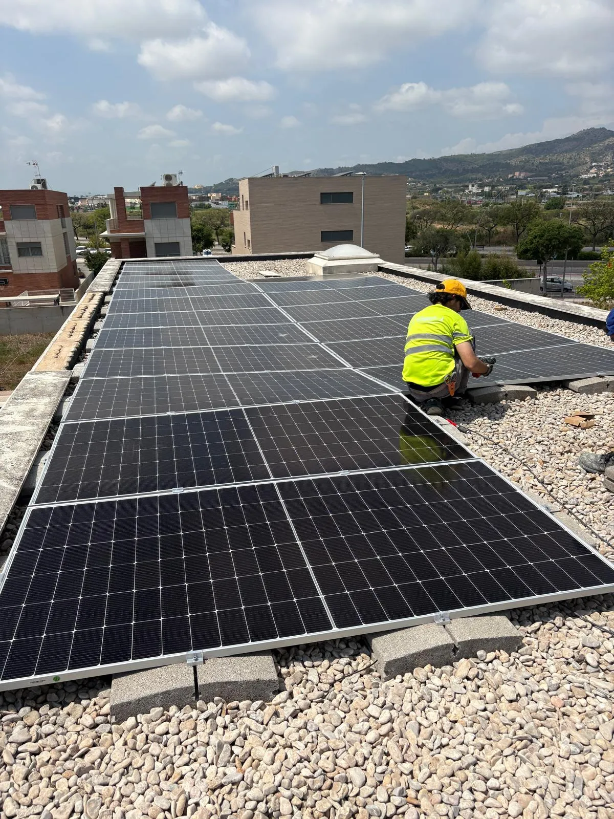 Operario instalando placas fotovoltaicas en una cubierta